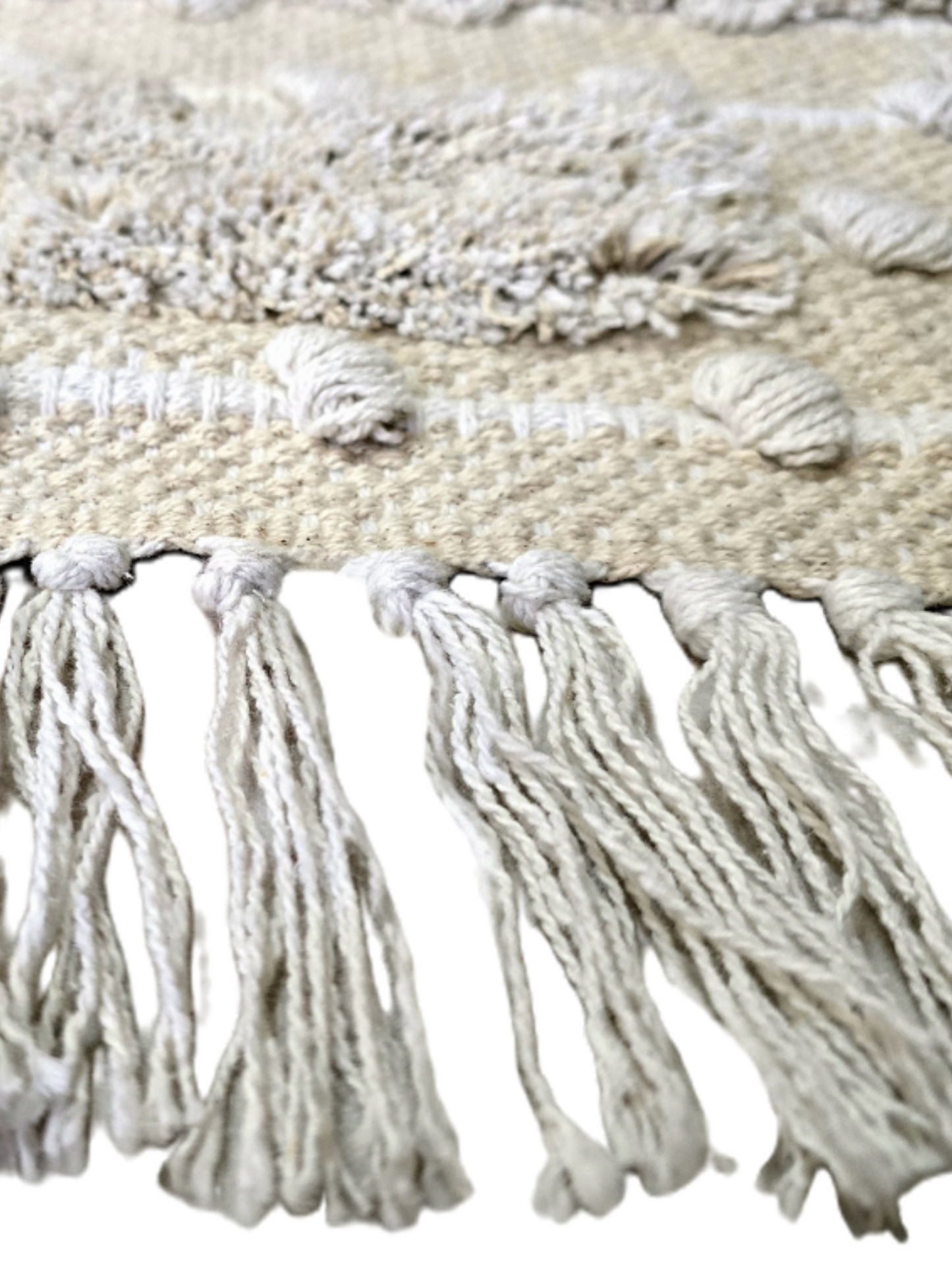 Finition avec franges naturelles artisanales sur un petit tapis bohème chic texturé.