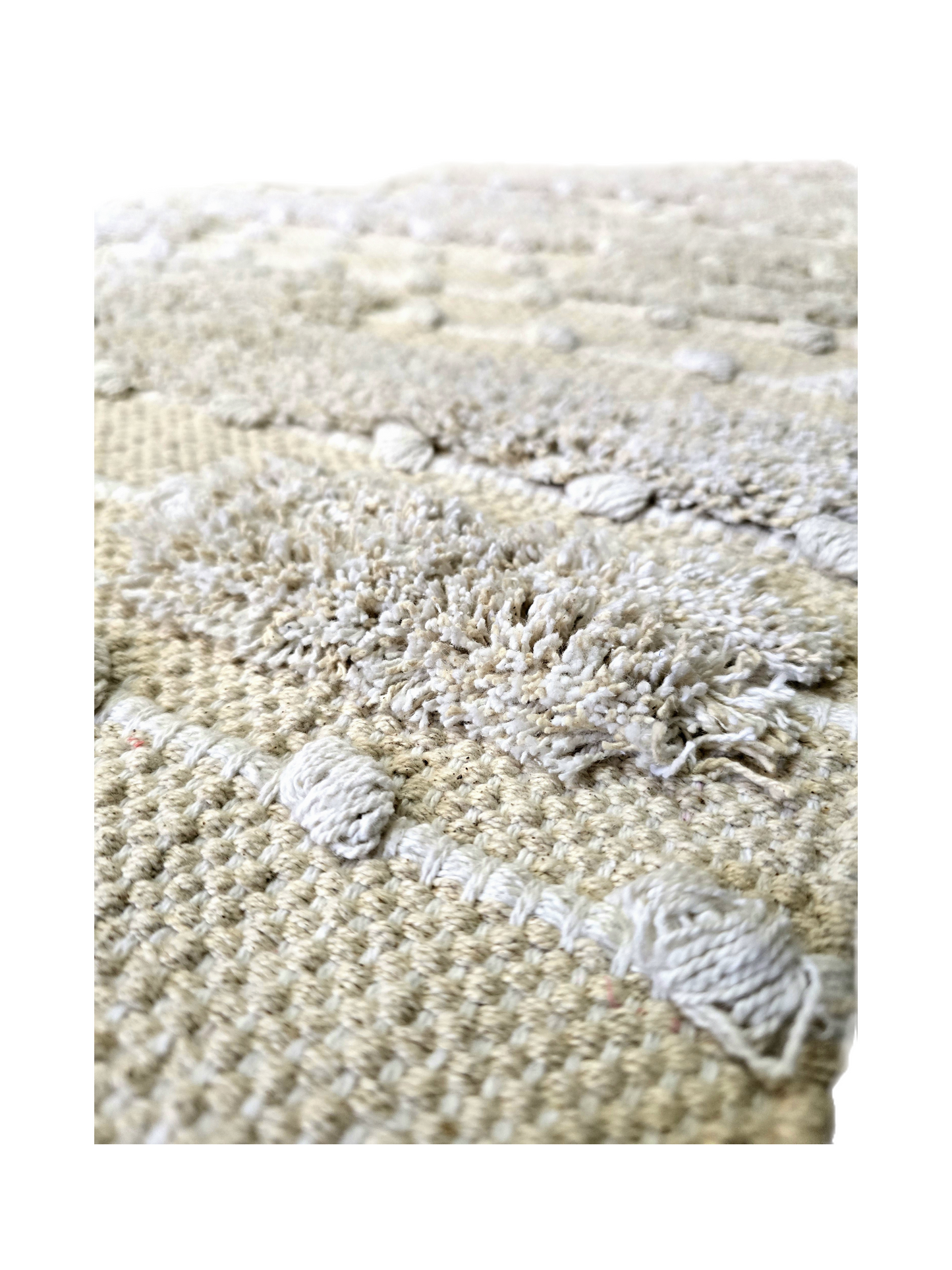 Gros plan sur la texture visuelle et tactile d'un tapis bohème chic 100% coton coloris naturel.