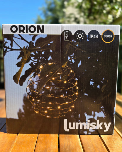 Boîte packaging ORION Lumisky posée sur table en bois en extérieur, face avant avec photo de la suspension allumée et logos IP44, solaire, batterie, 3000K