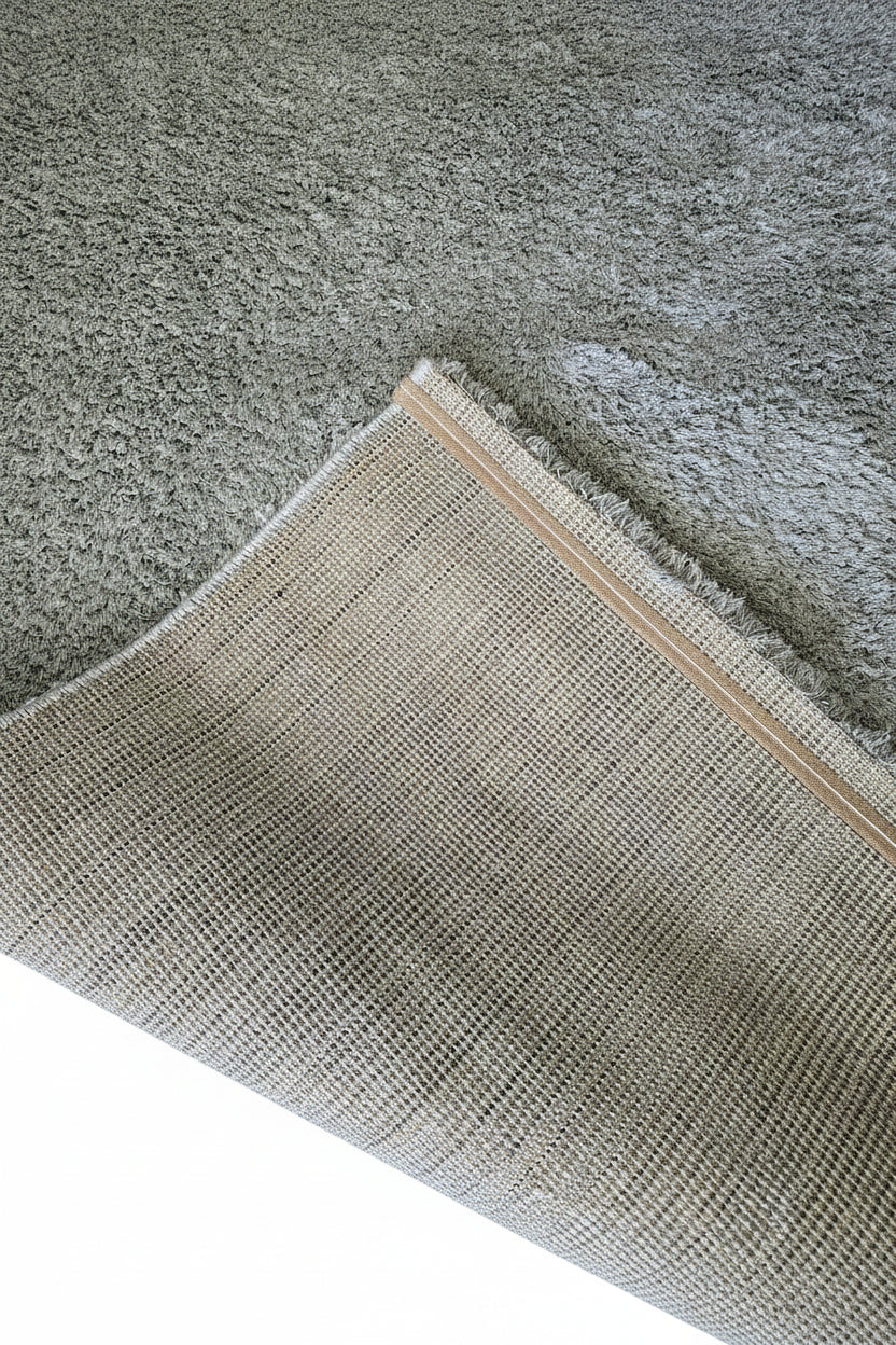 Vue du revers d'un tapis shaggy montrant la finition soignée et la robustesse du tissage pour une longue durée de vie.