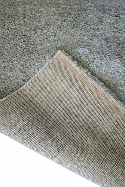 Vue du revers d'un tapis shaggy montrant la finition soignée et la robustesse du tissage pour une longue durée de vie.