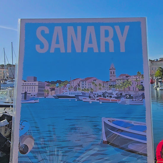 Vidéo — Présentation de l'affiche Rétropia Sanary directement sur le port de Sanary-sur-Mer, l'illustration confrontée au décor réel qui l'a inspirée — LLX ConceptStore
