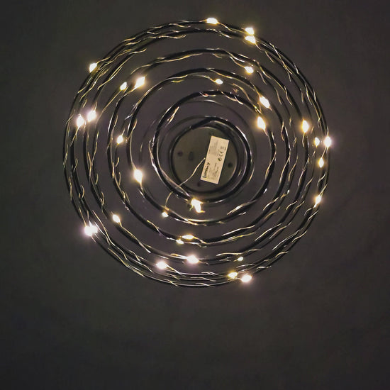 Vidéo — Suspension solaire ORION Lumisky présentée de nuit : tourbillon de micro-LEDs blanc chaud en effet lucioles, illuminant le jardin d'une lumière féerique — LLX ConceptStore
