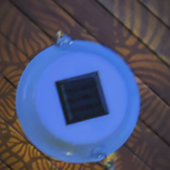 Vidéo — Lanterne solaire bohème Mini Rainbow Lumisky en métal blanc ajouré : vues alternées jour et nuit, motifs de feuilles projetant de jolis jeux d'ombres et une lumière LED blanc chaud — LLX ConceptStore
